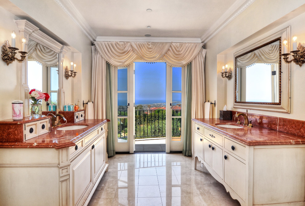 Imagen de cuarto de baño principal mediterráneo grande con puertas de armario de madera clara, encimera de mármol, baldosas y/o azulejos blancos y paredes beige