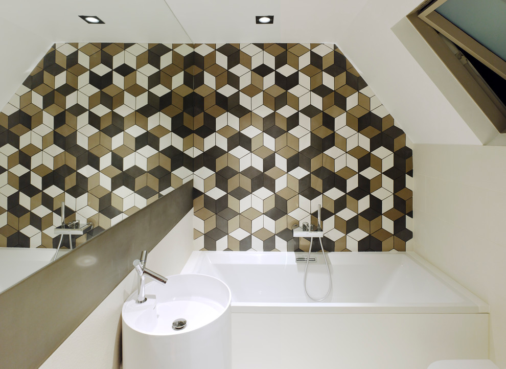 Example of a trendy multicolored tile drop-in bathtub design in London with a pedestal sink and white walls