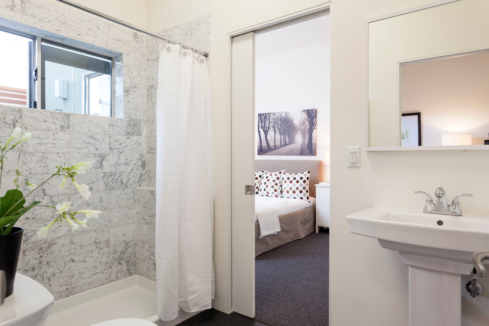 Ejemplo de cuarto de baño actual con lavabo con pedestal, ducha con cortina y ventanas