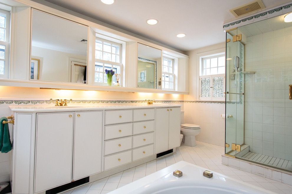 На фото: большая главная ванная комната в классическом стиле с плоскими фасадами, белыми фасадами, гидромассажной ванной, желтыми стенами, полом из керамической плитки и накладной раковиной