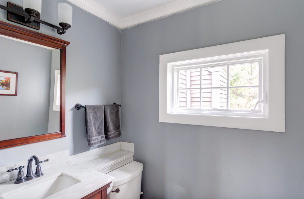 Idee per una stanza da bagno con doccia country di medie dimensioni con consolle stile comò, ante in legno scuro, doccia ad angolo, WC a due pezzi, pareti blu, pavimento con piastrelle in ceramica, lavabo da incasso, top in superficie solida, pavimento beige, porta doccia a battente e top beige