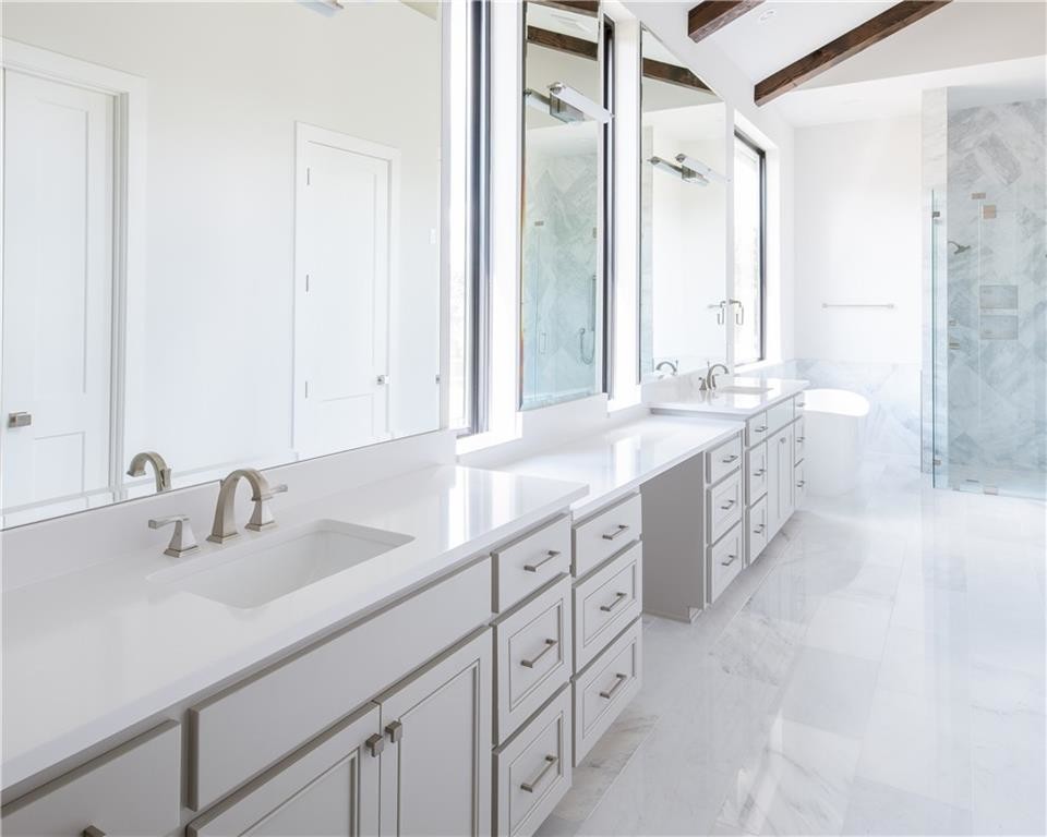 Idée de décoration pour une grande salle de bain principale minimaliste avec des portes de placard blanches, une baignoire indépendante, une douche ouverte, un mur blanc, un sol en marbre, un lavabo encastré, un sol blanc, une cabine de douche à porte battante et un plan de toilette blanc.