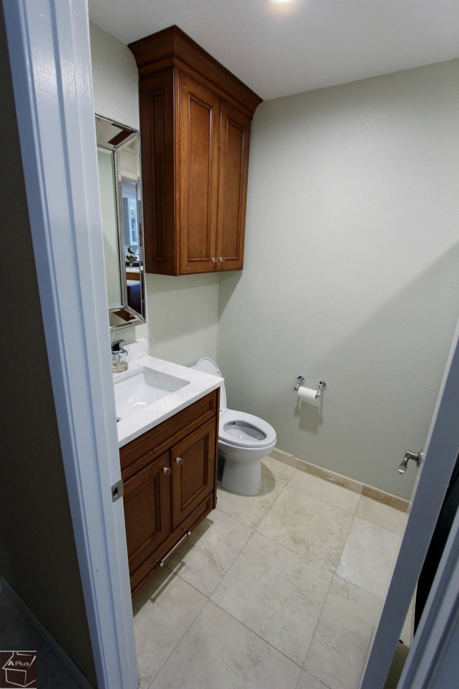Inredning av ett modernt litet badrum med dusch, med ett undermonterad handfat, luckor med infälld panel, skåp i mellenmörkt trä, bänkskiva i kvartsit, en toalettstol med separat cisternkåpa, vit kakel, blå väggar och klinkergolv i porslin