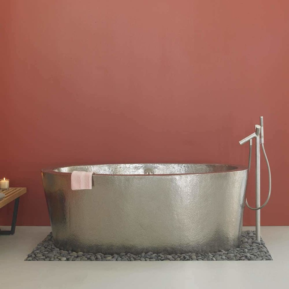 На фото: главная ванная комната среднего размера с отдельно стоящей ванной, оранжевыми стенами, полом из галечной плитки и серым полом