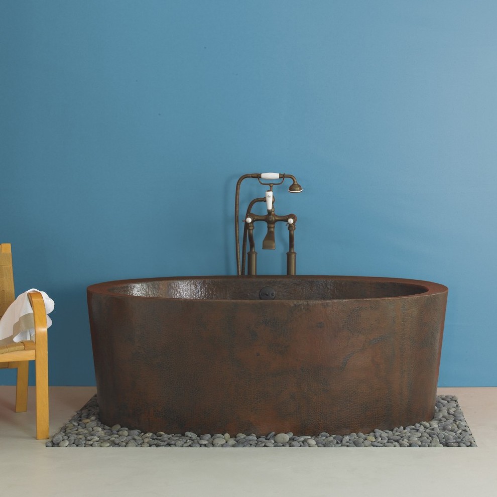Modelo de cuarto de baño principal de tamaño medio con bañera exenta, paredes azules, suelo de baldosas tipo guijarro y suelo gris