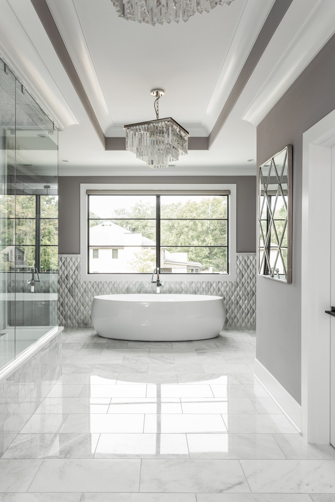 Medelhavsstil inredning av ett mycket stort en-suite badrum, med ett fristående badkar, en öppen dusch, grå kakel, marmorkakel, grå väggar och dusch med gångjärnsdörr
