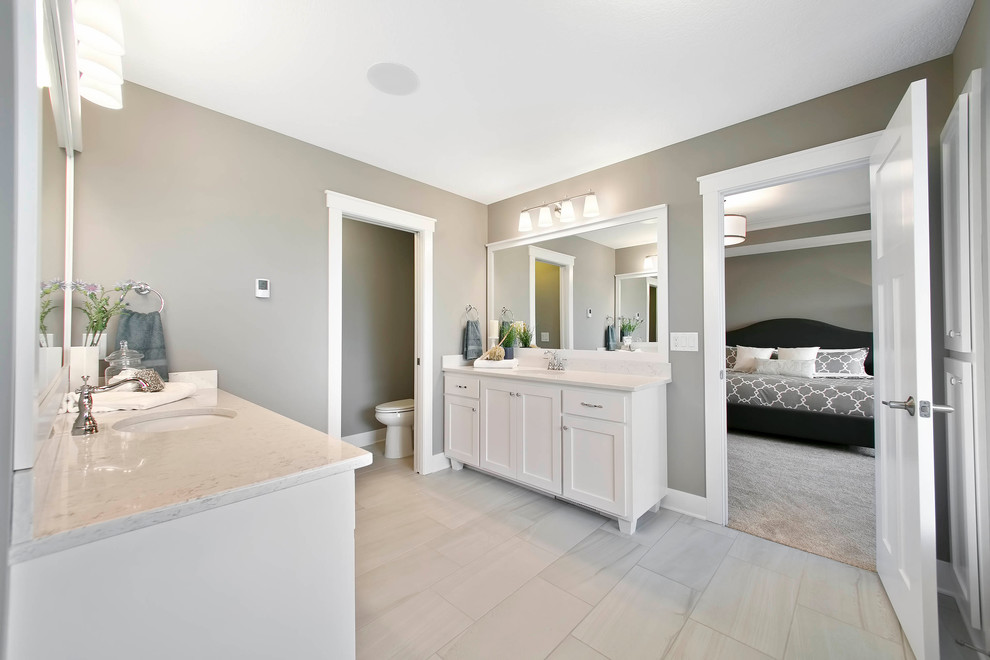 ミネアポリスにある高級な広いおしゃれなマスターバスルーム (白いキャビネット、白いタイル、グレーの壁、セラミックタイルの床、御影石の洗面台) の写真
