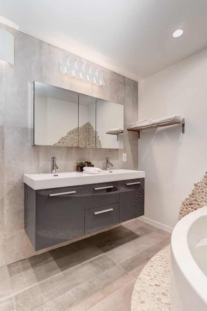 Exempel på ett mellanstort modernt en-suite badrum, med luckor med upphöjd panel, skåp i mörkt trä, ett hörnbadkar, en dusch i en alkov, en toalettstol med hel cisternkåpa, mosaik, grå väggar, mellanmörkt trägolv, ett integrerad handfat och bänkskiva i akrylsten