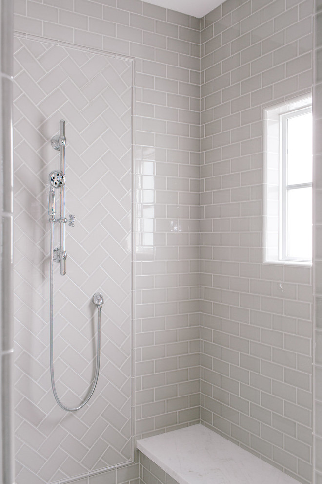 Exemple d'une salle de bain principale nature avec une baignoire indépendante, WC à poser, un carrelage gris, un carrelage métro, un mur gris, un sol en marbre, un lavabo encastré et un plan de toilette en marbre.