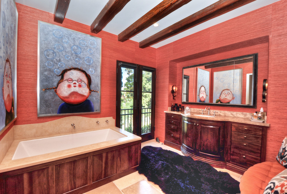 Inredning av ett medelhavsstil stort en-suite badrum, med släta luckor, skåp i mellenmörkt trä, ett hörnbadkar, beige kakel, röda väggar, travertin golv och granitbänkskiva