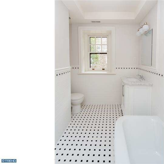 Photo of a small classic family bathroom in Philadelphia with a submerged sink, beaded cabinets, white cabinets, marble worktops, a corner bath, a two-piece toilet, white tiles, ceramic tiles, white walls and ceramic flooring.