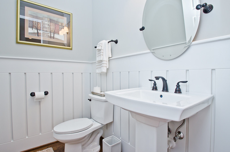 Idéer för att renovera ett mellanstort amerikanskt badrum, med ett piedestal handfat, en toalettstol med hel cisternkåpa, grå väggar och mellanmörkt trägolv