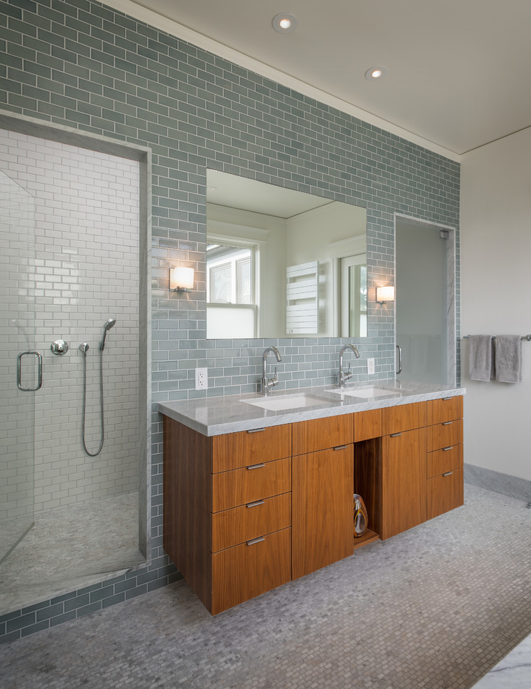 Идея дизайна: ванная комната в современном стиле с врезной раковиной, плоскими фасадами, фасадами цвета дерева среднего тона, душем в нише, серой плиткой, плиткой кабанчик и серой столешницей
