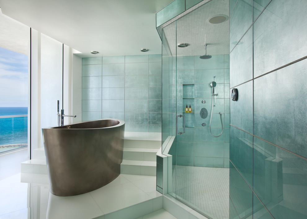 На фото: главная ванная комната в современном стиле с отдельно стоящей ванной и зеленой плиткой