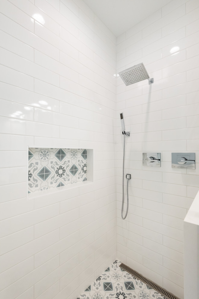 Alcove shower - large coastal master white tile and subway tile porcelain tile and blue floor alcove shower idea in Charleston with shaker cabinets, gray cabinets, a two-piece toilet, white walls, an integrated sink, quartz countertops, a hinged shower door and white countertops