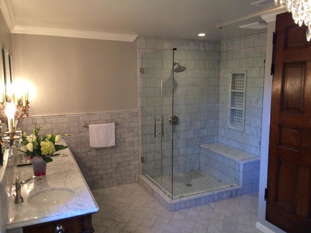 Example of a mid-sized ornate master gray tile and subway tile porcelain tile corner shower design in Indianapolis with recessed-panel cabinets, dark wood cabinets, gray walls, an undermount sink and marble countertops
