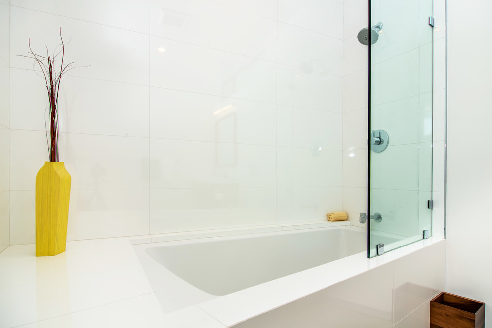 ロサンゼルスにあるモダンスタイルのおしゃれな浴室 (アルコーブ型浴槽、シャワー付き浴槽	、白いタイル、セラミックタイル、白い壁、磁器タイルの床) の写真