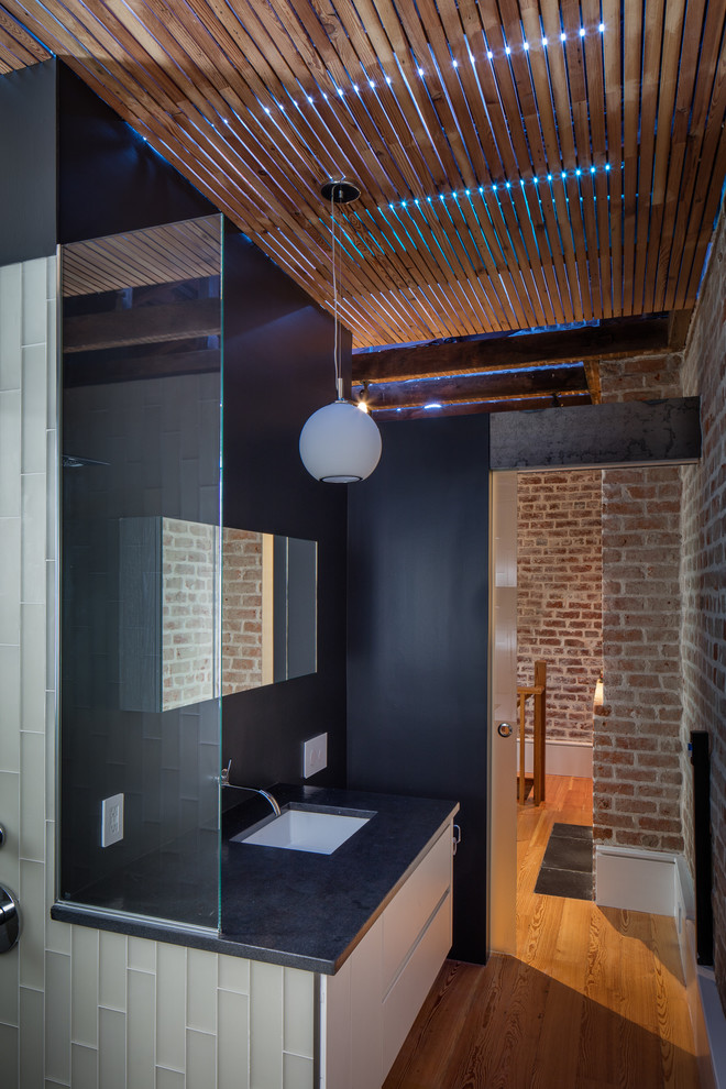 Стильный дизайн: ванная комната в современном стиле с плоскими фасадами, белыми фасадами, белой плиткой, стеклянной плиткой, черными стенами, паркетным полом среднего тона и врезной раковиной - последний тренд