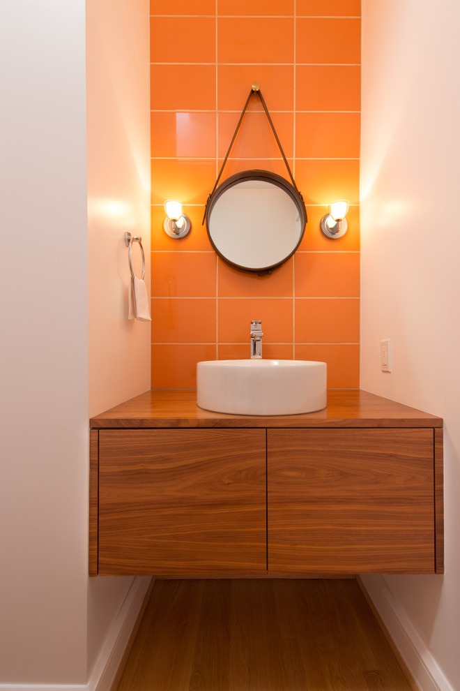 Idéer för att renovera ett litet funkis badrum med dusch, med ett fristående handfat, släta luckor, skåp i mörkt trä, träbänkskiva, orange kakel, porslinskakel, vita väggar och ljust trägolv