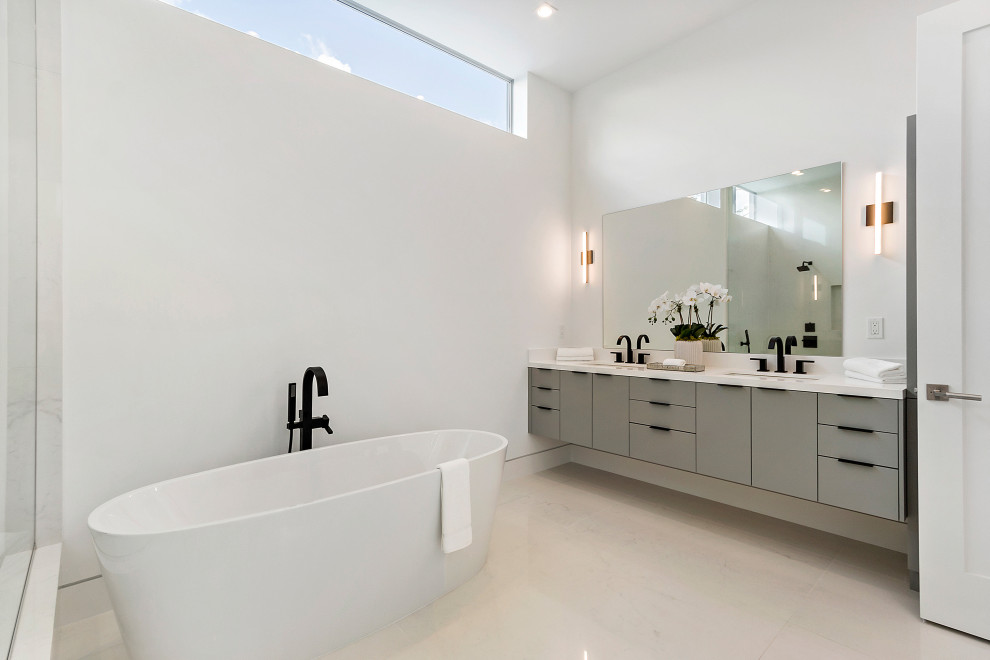 Inredning av ett modernt stort vit vitt en-suite badrum, med släta luckor, grå skåp, ett fristående badkar, vita väggar, klinkergolv i porslin, ett undermonterad handfat och beiget golv