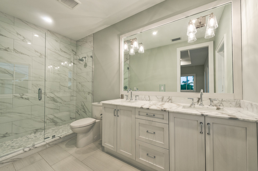 Exempel på ett stort badrum för barn, med luckor med infälld panel, grå skåp, en öppen dusch, en toalettstol med separat cisternkåpa, grå kakel, marmorkakel, grå väggar, klinkergolv i keramik, ett undermonterad handfat, marmorbänkskiva, grått golv och dusch med gångjärnsdörr