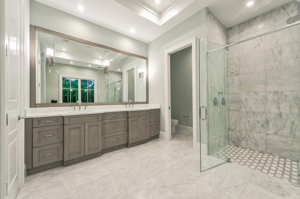 Bathroom - large master gray tile and ceramic tile marble floor and gray floor bathroom idea with recessed-panel cabinets, gray cabinets, a two-piece toilet, gray walls, an undermount sink, granite countertops and a hinged shower door