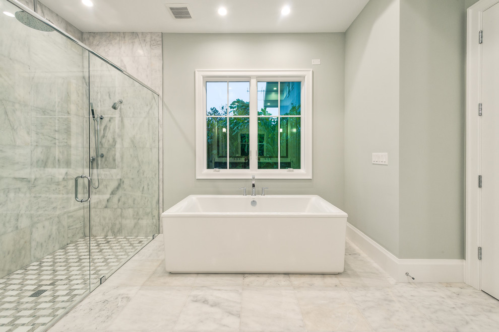 Bild på ett stort en-suite badrum, med luckor med infälld panel, grå skåp, ett fristående badkar, en öppen dusch, en toalettstol med separat cisternkåpa, grå kakel, keramikplattor, grå väggar, marmorgolv, ett undermonterad handfat, granitbänkskiva, grått golv och dusch med gångjärnsdörr