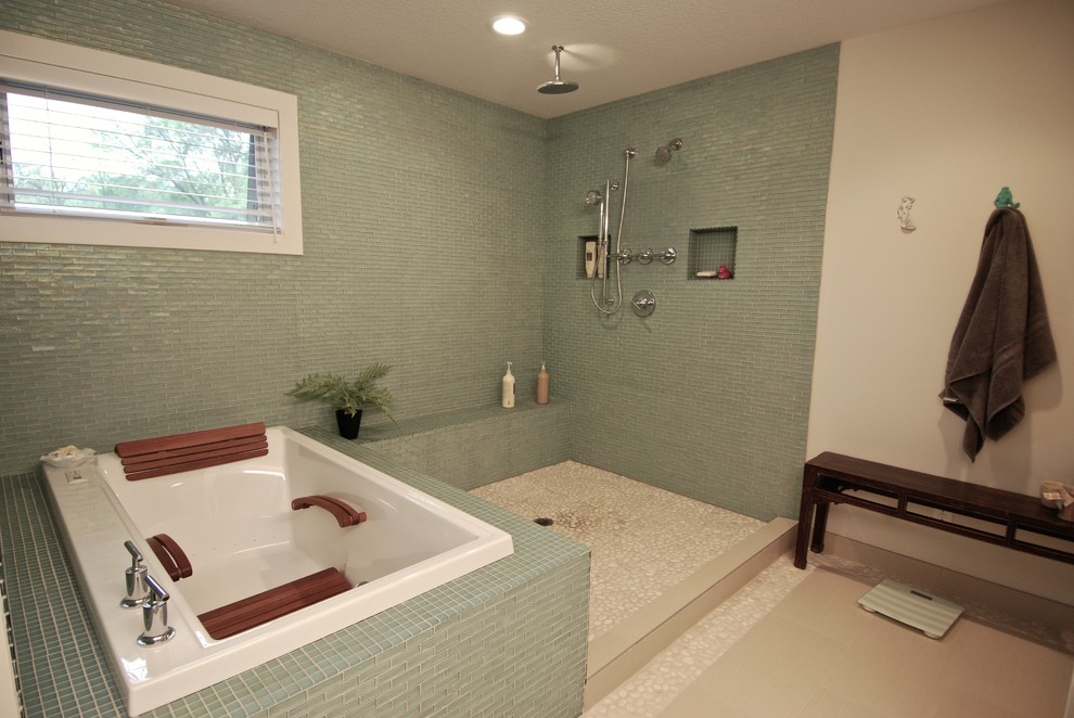 Medium sized retro ensuite bathroom in Minneapolis with flat-panel cabinets, medium wood cabinets, a built-in bath, a walk-in shower, a one-piece toilet, blue tiles, glass tiles, white walls, ceramic flooring, a submerged sink and granite worktops.