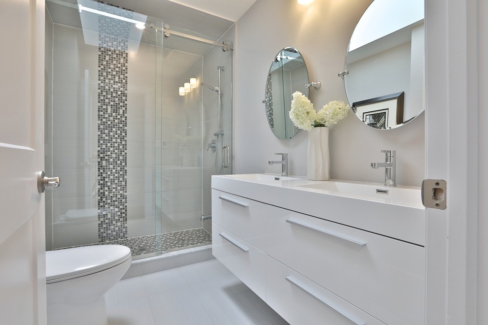 Medium sized contemporary shower room bathroom in Toronto with flat-panel cabinets, white cabinets, an alcove shower, a one-piece toilet, black and white tiles, grey tiles, multi-coloured tiles, ceramic tiles, grey walls, ceramic flooring, a submerged sink, grey floors and a sliding door.