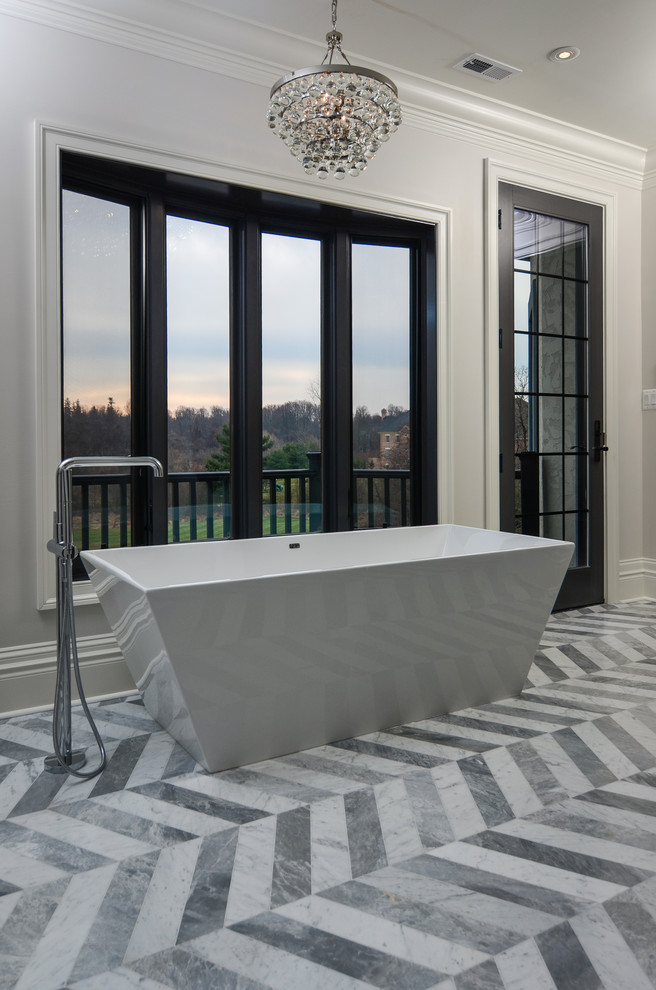 Esempio di una grande stanza da bagno padronale minimal con vasca freestanding, pareti grigie e pavimento in marmo