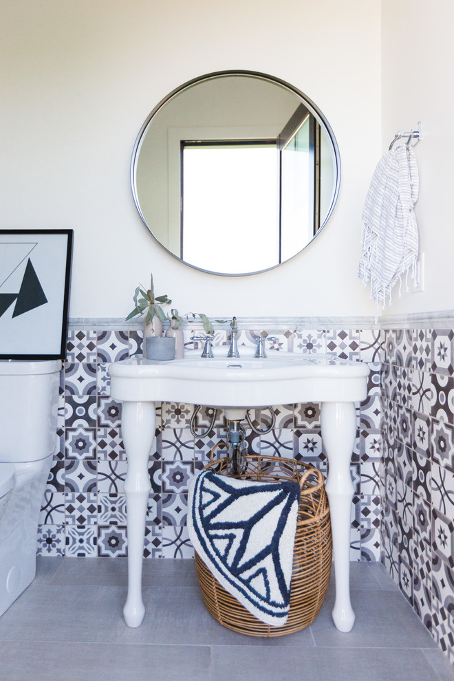 Imagen de cuarto de baño mediterráneo de tamaño medio con sanitario de una pieza, baldosas y/o azulejos blancas y negros, baldosas y/o azulejos en mosaico, aseo y ducha, lavabo tipo consola y suelo gris