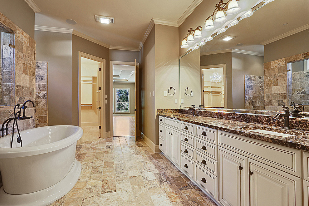 Elegant master beige tile and stone tile travertine floor bathroom photo in New Orleans with an undermount sink, raised-panel cabinets, white cabinets, granite countertops and beige walls