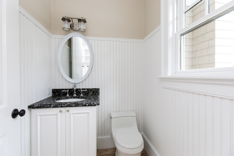 Ejemplo de cuarto de baño tradicional de tamaño medio con armarios con paneles con relieve, puertas de armario negras, bañera empotrada, ducha empotrada, sanitario de una pieza, paredes blancas, aseo y ducha y encimera de mármol
