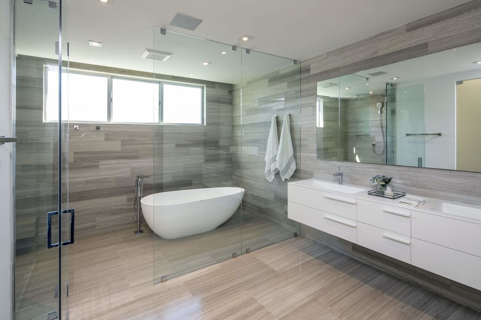 マイアミにある広いビーチスタイルのおしゃれなマスターバスルーム (白いキャビネット、置き型浴槽、グレーのタイル、大理石タイル、大理石の床、一体型シンク、グレーの床、開き戸のシャワー、白い洗面カウンター) の写真