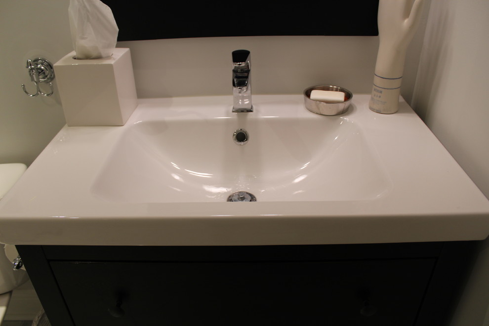 Inspiration for a small contemporary 3/4 white tile and stone tile mosaic tile floor bathroom remodel in Toronto with flat-panel cabinets, black cabinets, a one-piece toilet, white walls, an integrated sink and laminate countertops