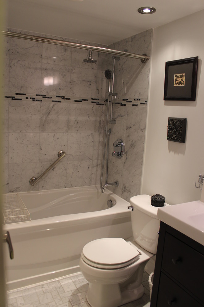 Bild på ett litet funkis badrum med dusch, med släta luckor, svarta skåp, vit kakel, stenkakel, mosaikgolv, ett platsbyggt badkar, en dusch/badkar-kombination, en toalettstol med hel cisternkåpa, vita väggar, ett integrerad handfat och laminatbänkskiva