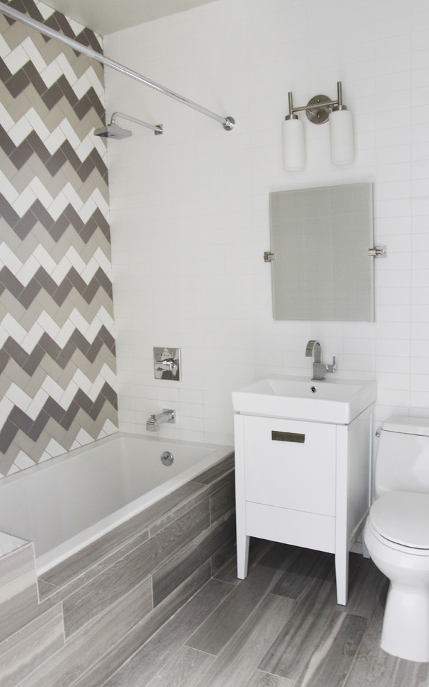 Idéer för att renovera ett mellanstort funkis badrum med dusch, med släta luckor, vita skåp, ett badkar i en alkov, en dusch/badkar-kombination, en toalettstol med hel cisternkåpa, grå kakel, vit kakel, keramikplattor, vita väggar, klinkergolv i porslin, ett integrerad handfat, bänkskiva i kvarts, grått golv och dusch med duschdraperi