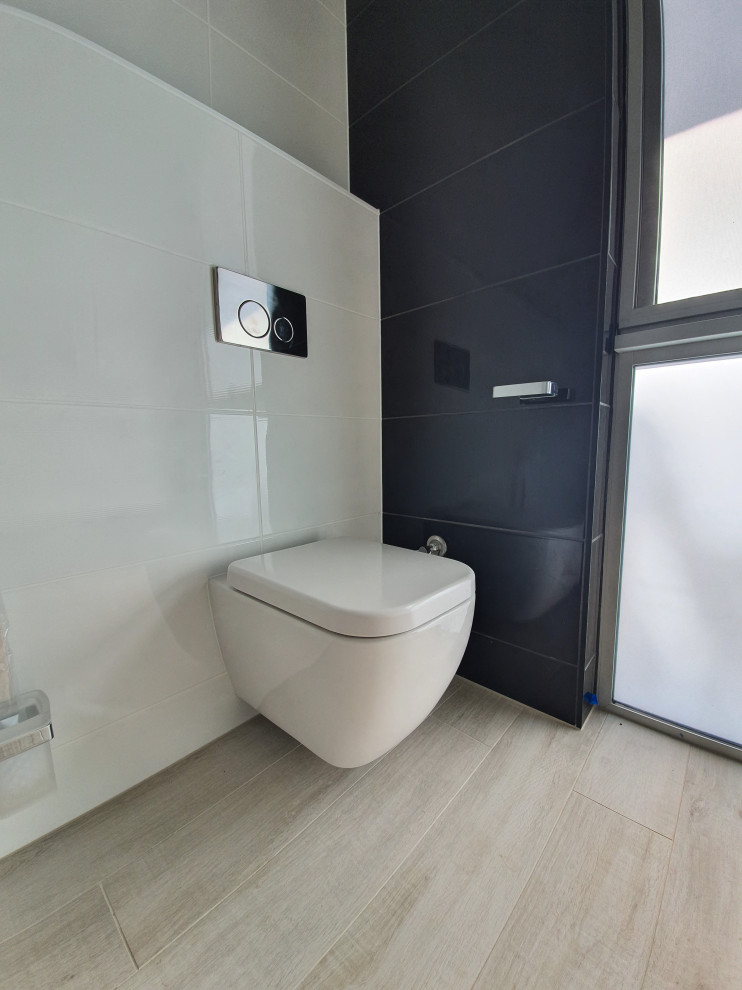 Idéer för mellanstora funkis svart badrum, med luckor med infälld panel, vita skåp, en öppen dusch, en vägghängd toalettstol, svart kakel, keramikplattor, vita väggar, klinkergolv i keramik, bänkskiva i akrylsten, beiget golv och med dusch som är öppen