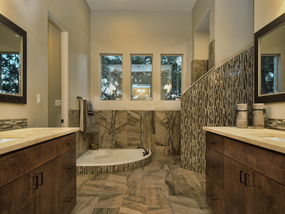 Contemporary half tiled bathroom in Austin with a corner bath.