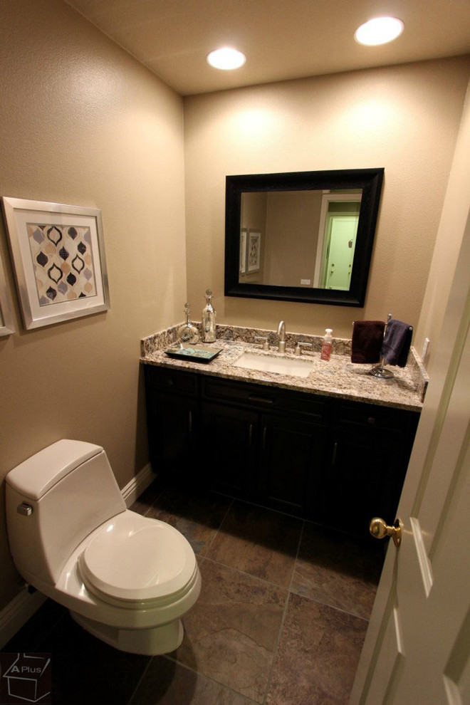Cette image montre une petite salle d'eau traditionnelle en bois foncé avec un lavabo posé, un placard avec porte à panneau encastré, un plan de toilette en granite, WC séparés, un carrelage multicolore, des dalles de pierre, un mur beige et un sol en carrelage de porcelaine.
