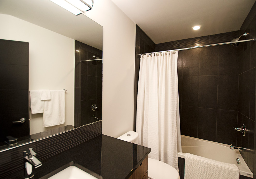Aménagement d'une salle de bain contemporaine en bois brun avec un lavabo encastré, un placard à porte plane, un plan de toilette en granite, une baignoire en alcôve, un combiné douche/baignoire, WC séparés, un carrelage gris et des carreaux de porcelaine.