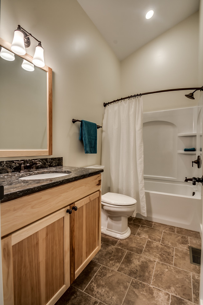 Photo of a medium sized classic family bathroom in New York with a submerged sink, recessed-panel cabinets, medium wood cabinets, engineered stone worktops, a corner bath, a shower/bath combination, a two-piece toilet, beige tiles, ceramic tiles, beige walls and ceramic flooring.