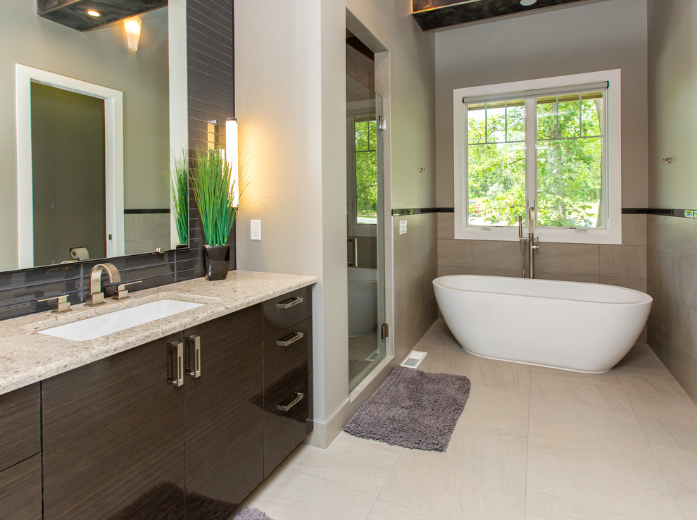 Immagine di una stanza da bagno contemporanea con vasca freestanding, top in granito e lavabo sottopiano