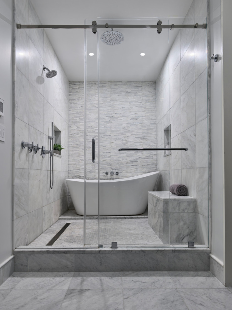 Klassisk inredning av ett en-suite badrum, med ett fristående badkar, våtrum, vit kakel, marmorkakel, vita väggar, marmorgolv, grått golv och dusch med skjutdörr