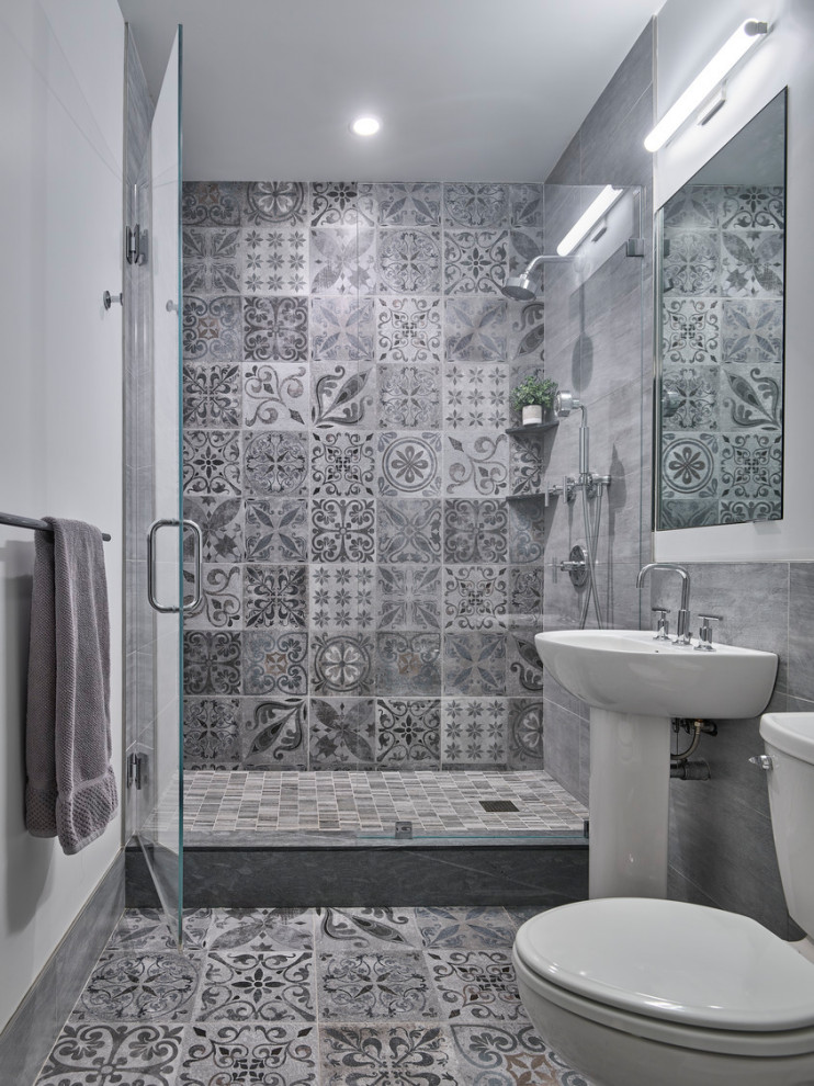 Foto de cuarto de baño tradicional renovado con ducha empotrada, sanitario de dos piezas, baldosas y/o azulejos grises, baldosas y/o azulejos de cemento, paredes blancas, suelo de azulejos de cemento, aseo y ducha, lavabo con pedestal, suelo gris y ducha con puerta con bisagras