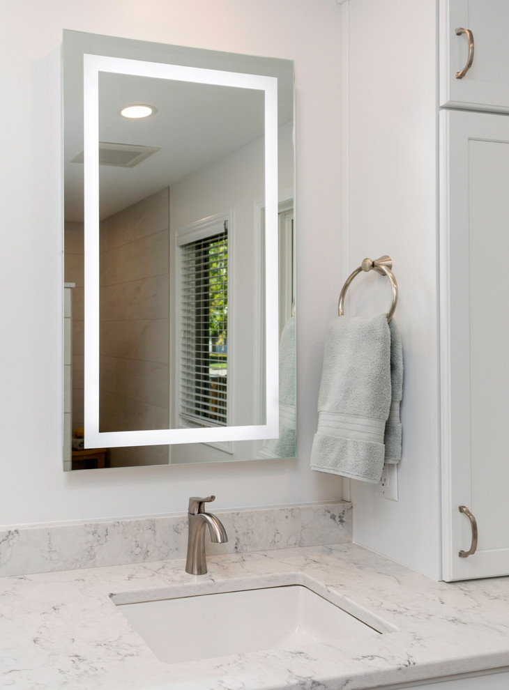 Example of a mid-sized transitional master ceramic tile and gray floor bathroom design in Other with recessed-panel cabinets, white cabinets, a two-piece toilet, white walls, an undermount sink, quartz countertops and white countertops