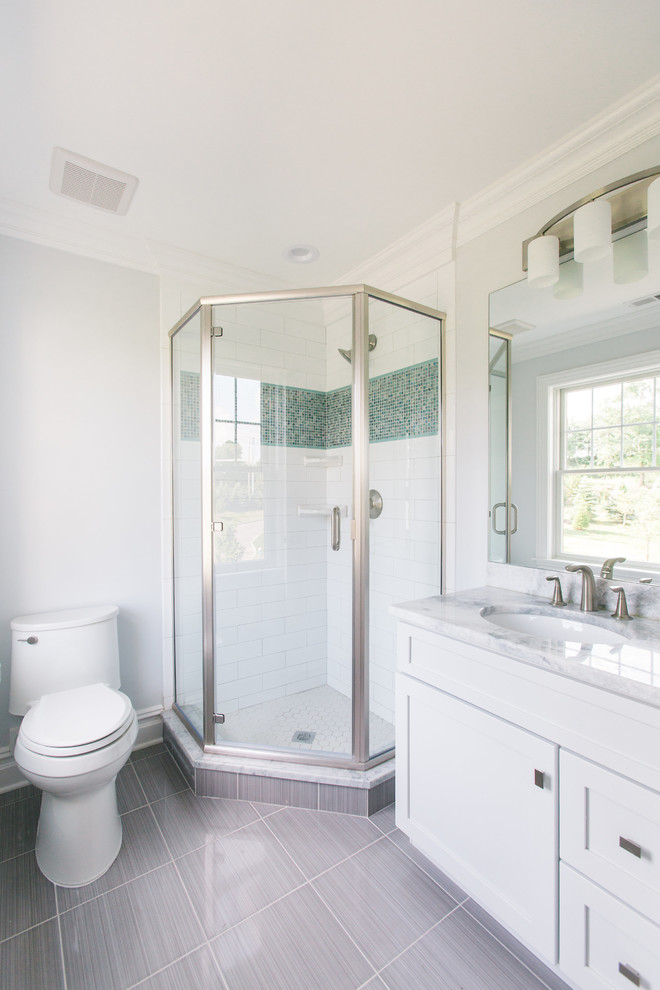 Example of a small classic 3/4 white tile and ceramic tile ceramic tile and gray floor corner shower design in New York with recessed-panel cabinets, white cabinets, a one-piece toilet, gray walls, an undermount sink, granite countertops and a hinged shower door