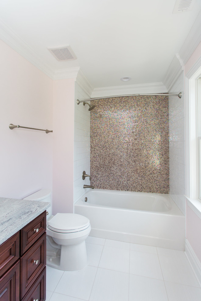 Mid-sized elegant kids' multicolored tile and ceramic tile ceramic tile and white floor bathroom photo in New York with recessed-panel cabinets, dark wood cabinets, a one-piece toilet, pink walls, an undermount sink and granite countertops