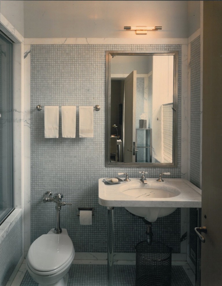 Foto di una stanza da bagno con doccia minimalista di medie dimensioni con lavabo a consolle, top in marmo, doccia alcova, WC monopezzo, piastrelle bianche, piastrelle di vetro, pareti bianche e pavimento con piastrelle a mosaico