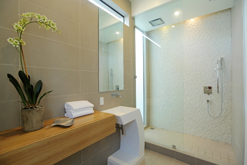 Foto de cuarto de baño actual con lavabo con pedestal, encimera de madera, ducha esquinera, baldosas y/o azulejos beige y ventanas